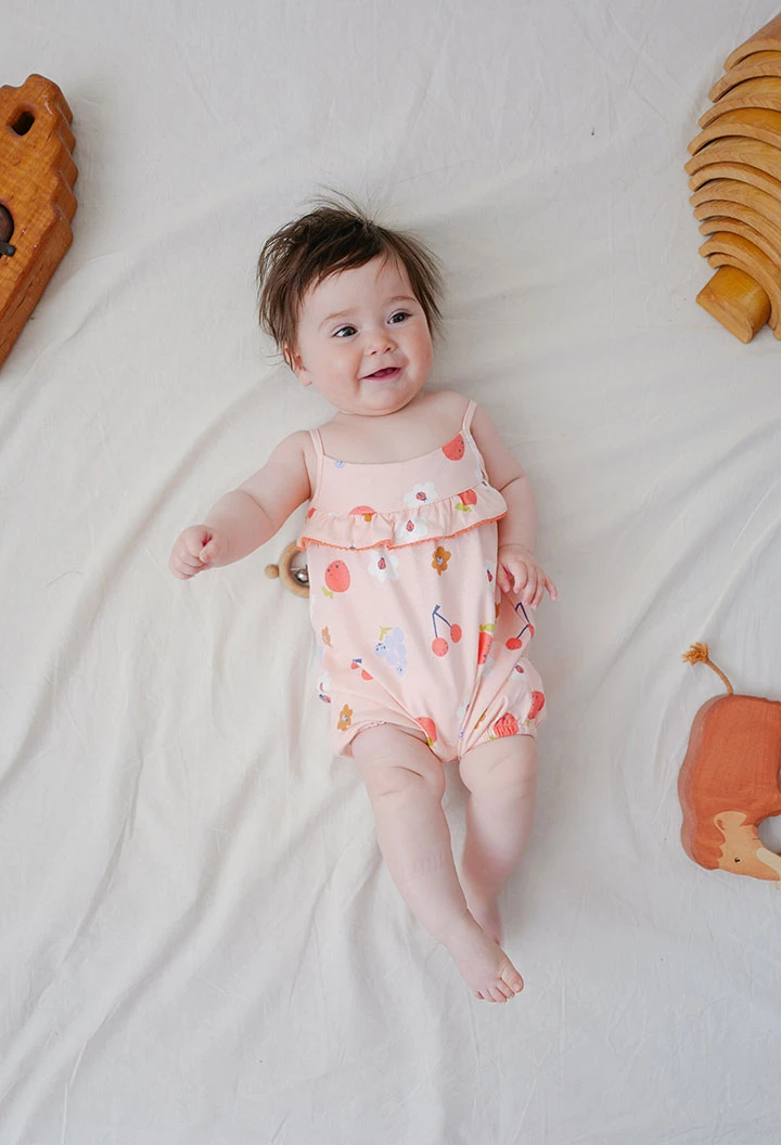 Combinaison en tricot pour bébé fille avec imprimé de fleurs en couleur rose.