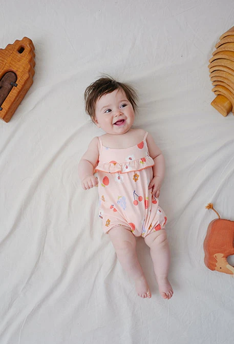 Combinaison en tricot pour bébé fille avec imprimé de fleurs en couleur rose.