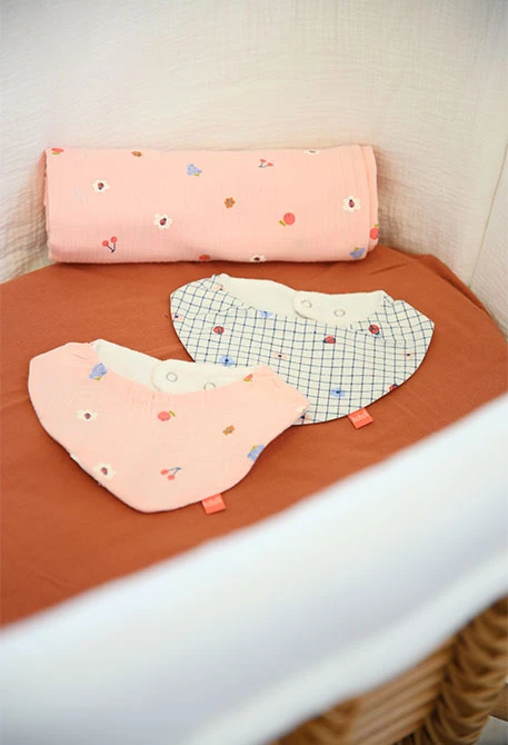 2-pack of knitted bibs for baby in pink and white with checkered pattern