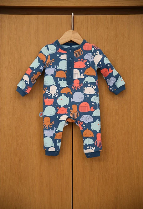 Grenouillère en tricot pour bébé garçon de couleur bleue avec motif.