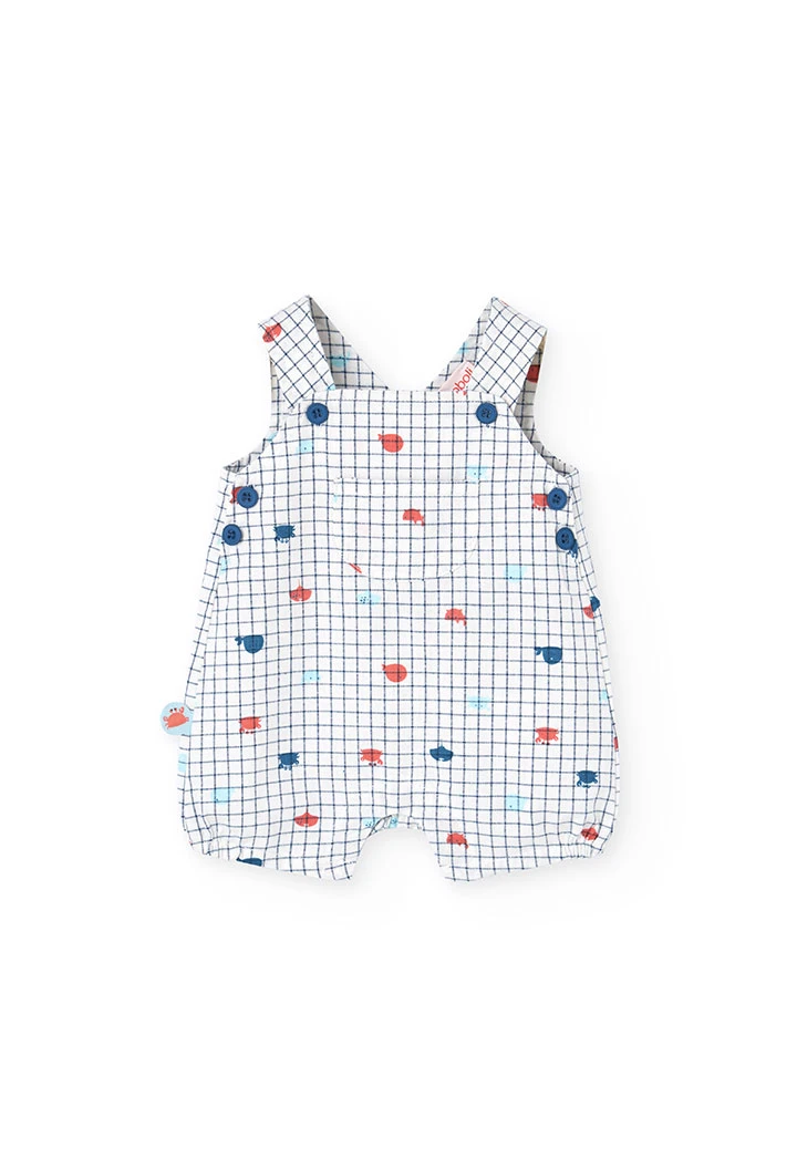 Salopette in popeline per bambino in colore bianco con stampa a quadri in blu e rosso.