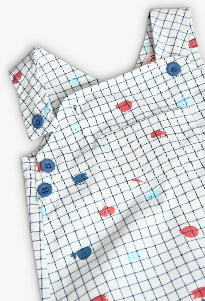 Salopette in popeline per bambino in colore bianco con stampa a quadri in blu e rosso.