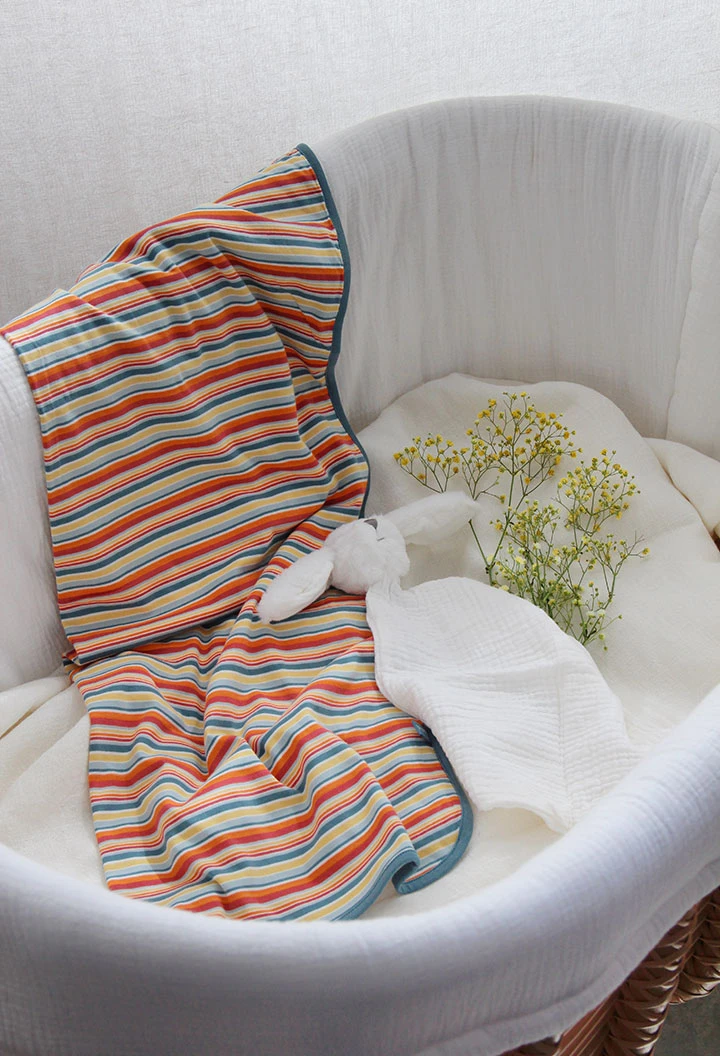 Copertina a maglia per bambino in colore bianco con stampa multicolore