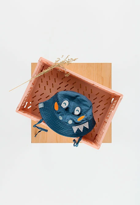 Bonnet en popeline pour bébé avec un design amusant de couleur verte.