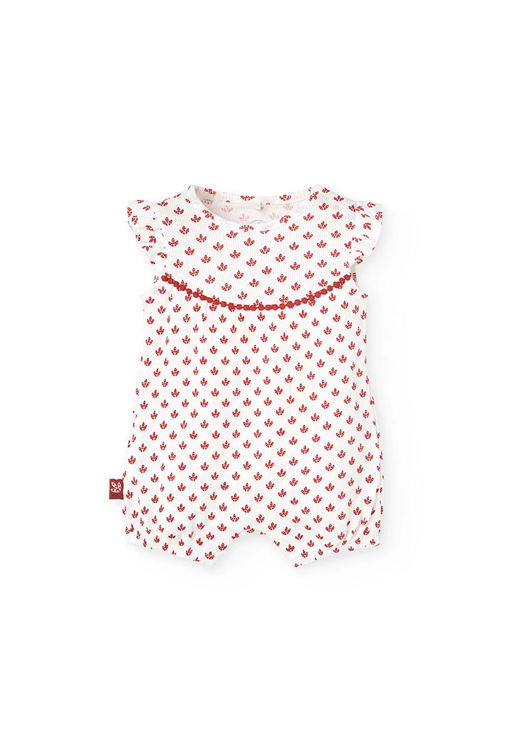 Combinaison en tricot pour bébé fille de couleur blanche avec un motif de fleurs rouges.