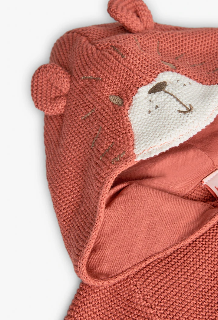Giacca lavorata a maglia per neonato di colore arancione.