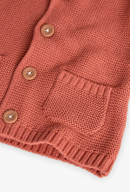 Giacca lavorata a maglia per neonato di colore arancione.