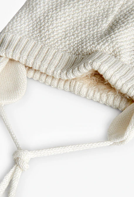 Weißer Babymütze mit Pompons