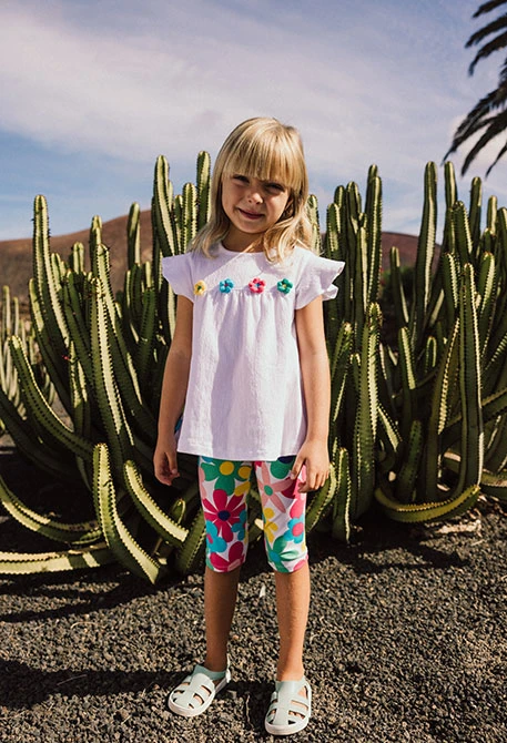 T-shirt de malha para bebé menina em cor branca com design de flores bordadas.