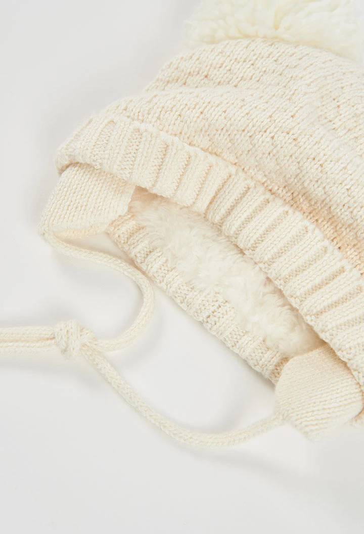 Weißes Babymütze mit Pompons