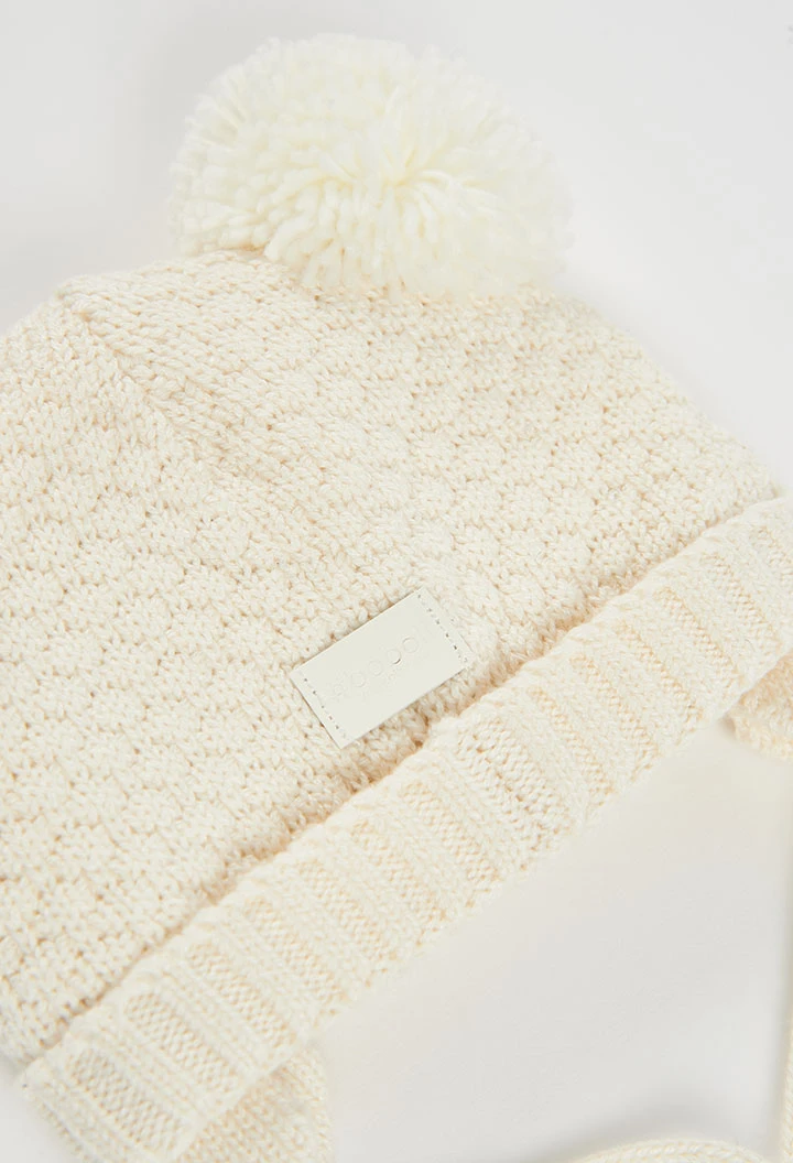 White baby hat with pompoms