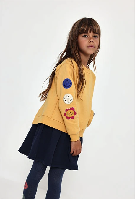 Gelbes Plüschkleid mit Emoticon-Patches
