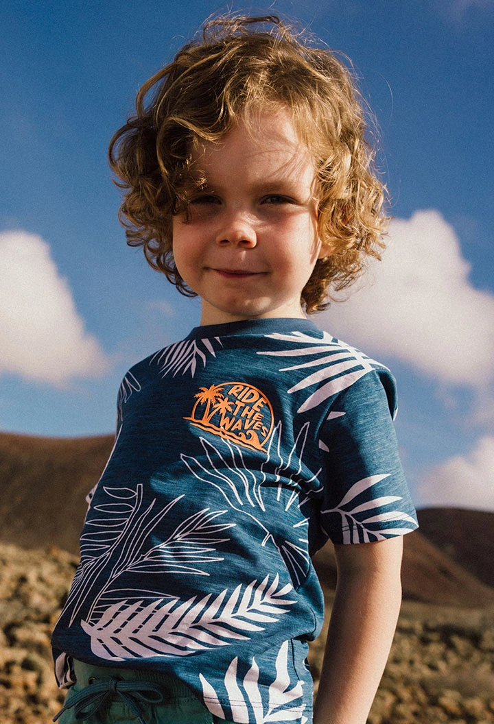 Maglietta in maglia per bambino di colore blu con design tropicale.