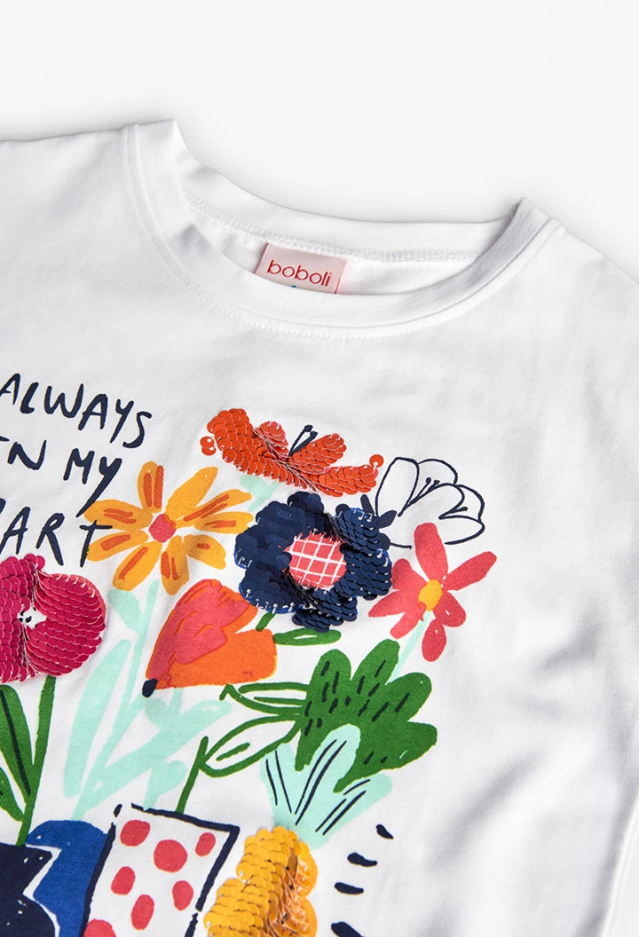 Maglietta a maglia per bambina in bianco con stampa floreale.