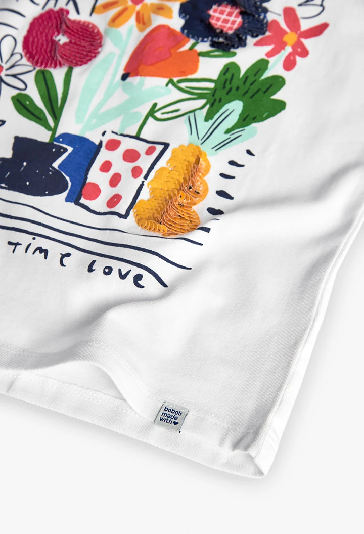 Maglietta a maglia per bambina in bianco con stampa floreale.