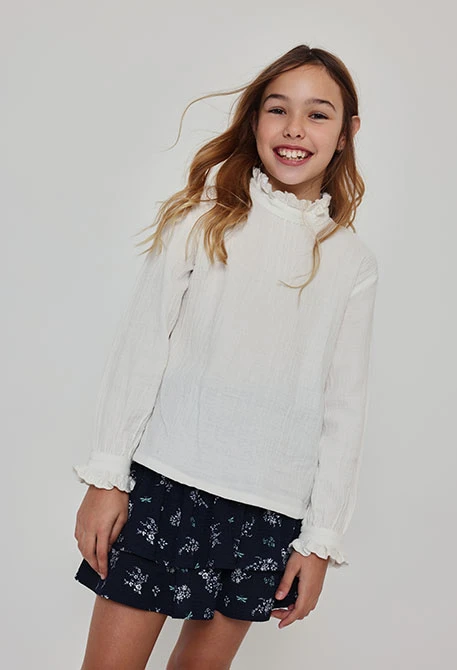 Blouse en mousseline blanche avec volants et col froncé