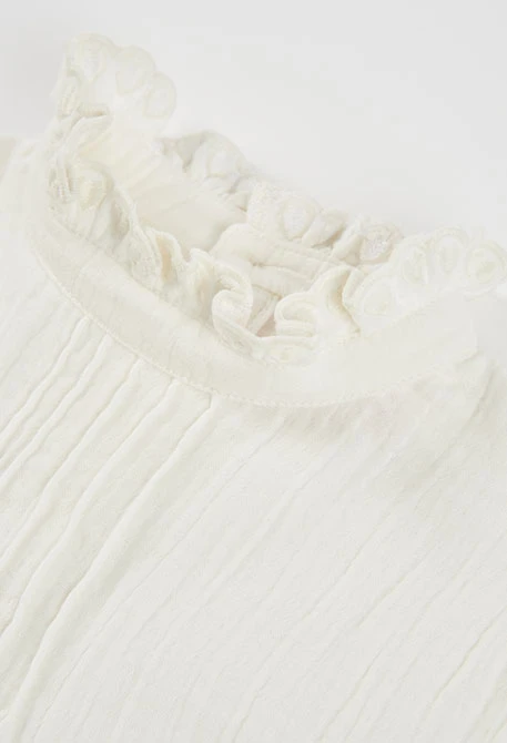 Blouse en mousseline blanche avec volants et col froncé