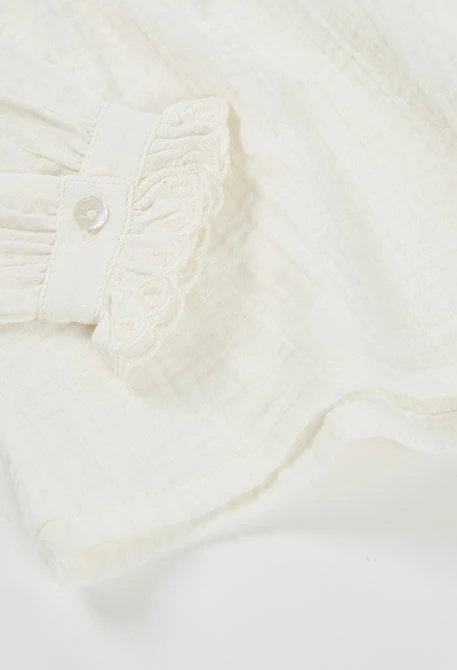 Blouse en mousseline blanche avec volants et col froncé