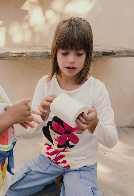 Maglietta in maglia per bambina a maniche lunghe di colore bianco.