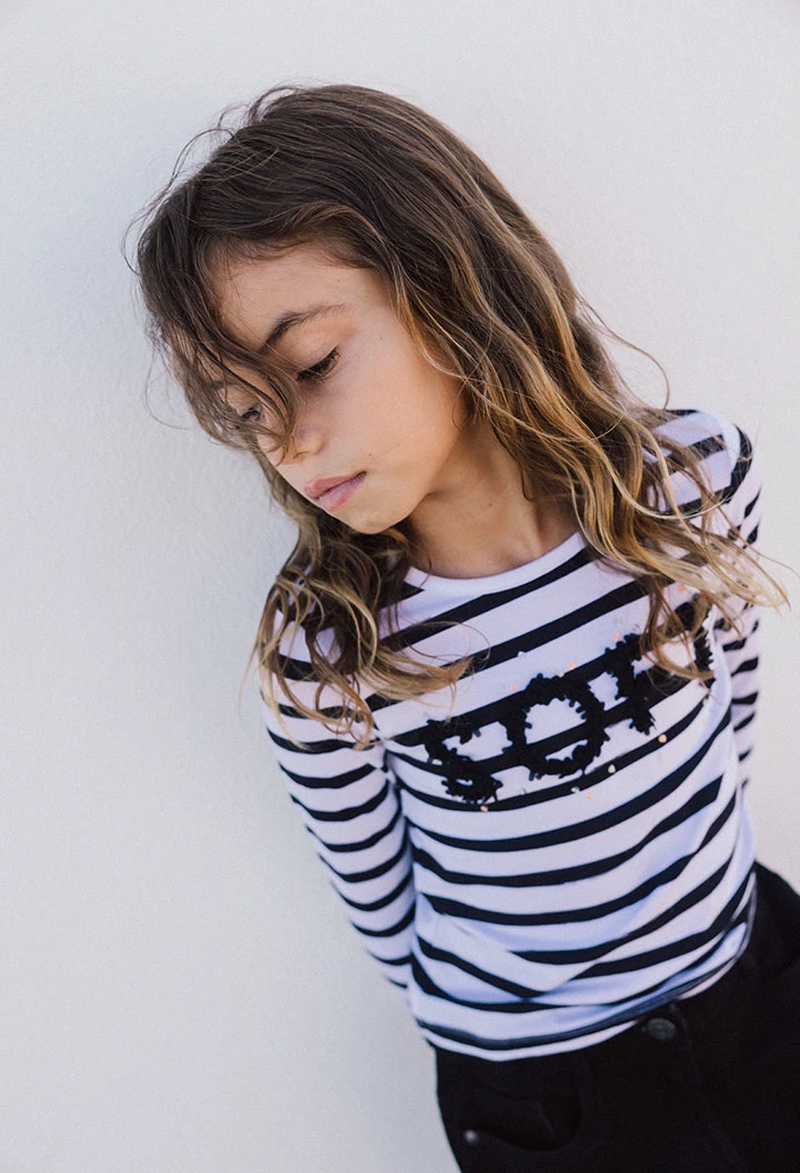 Maglietta a maglia per bambina con design a righe nei colori bianco e nero