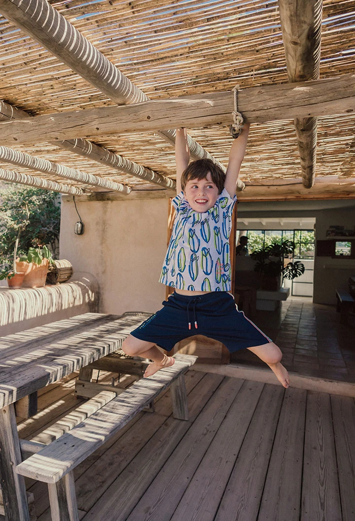 Camiseta de punto para niño en color blanco con estampado de surfistas