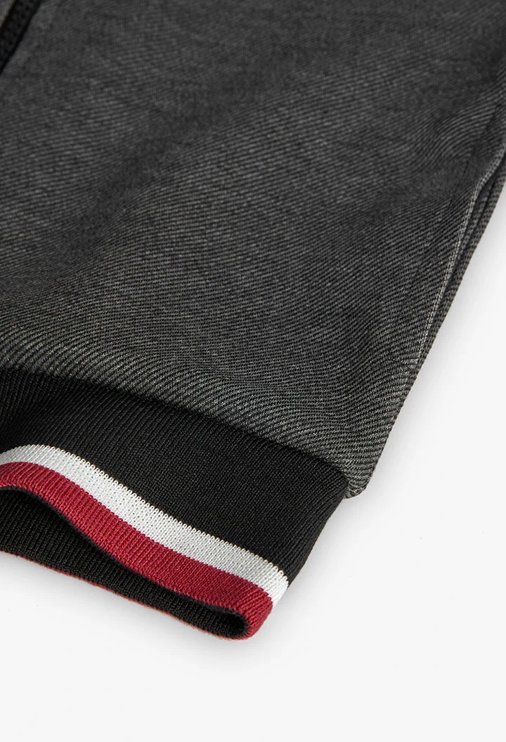 Black knit boy´s jacket with red and white trim