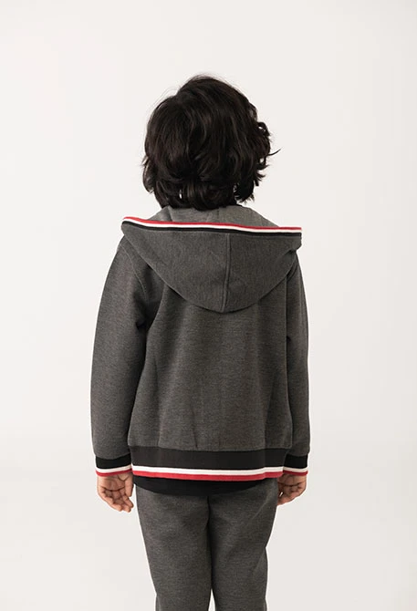 Black knit boy´s jacket with red and white trim