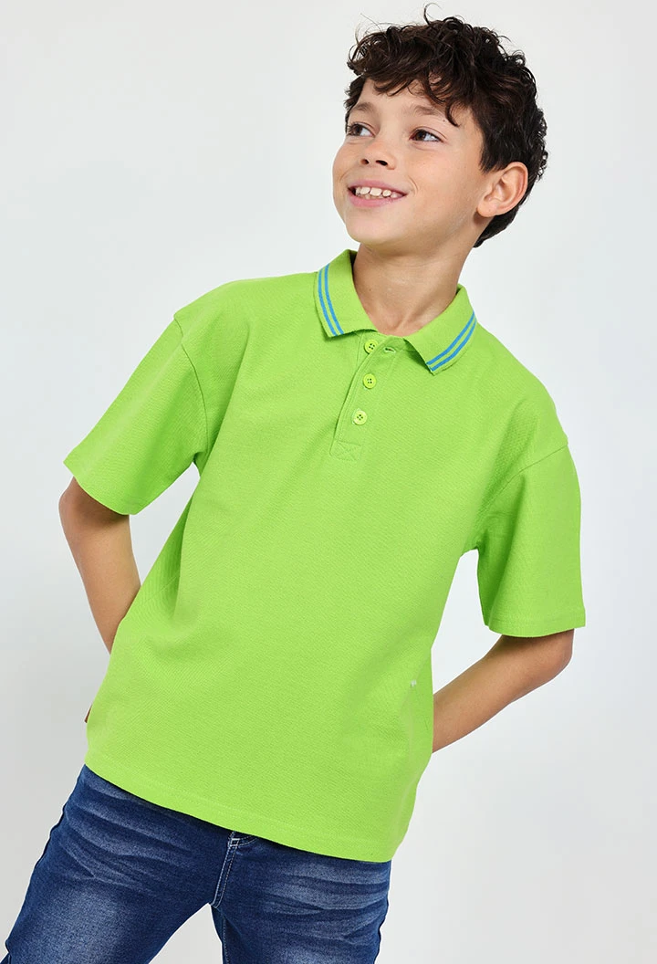 Polo in piqué per bambino di colore verde.