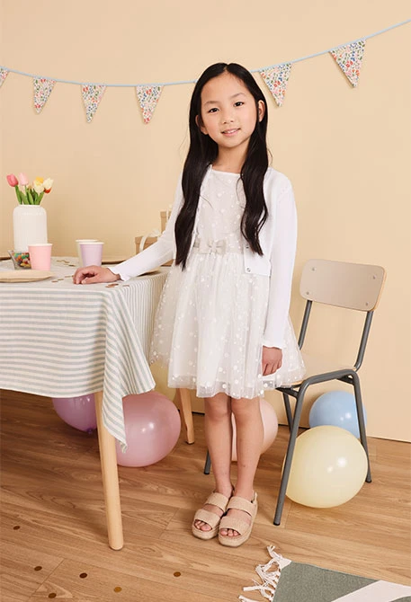 Baby-Mädchen-Tüllkleid mit Tupfenmuster in Weiß.