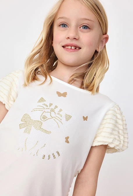 Maglietta di maglia per neonata in colore bianco.