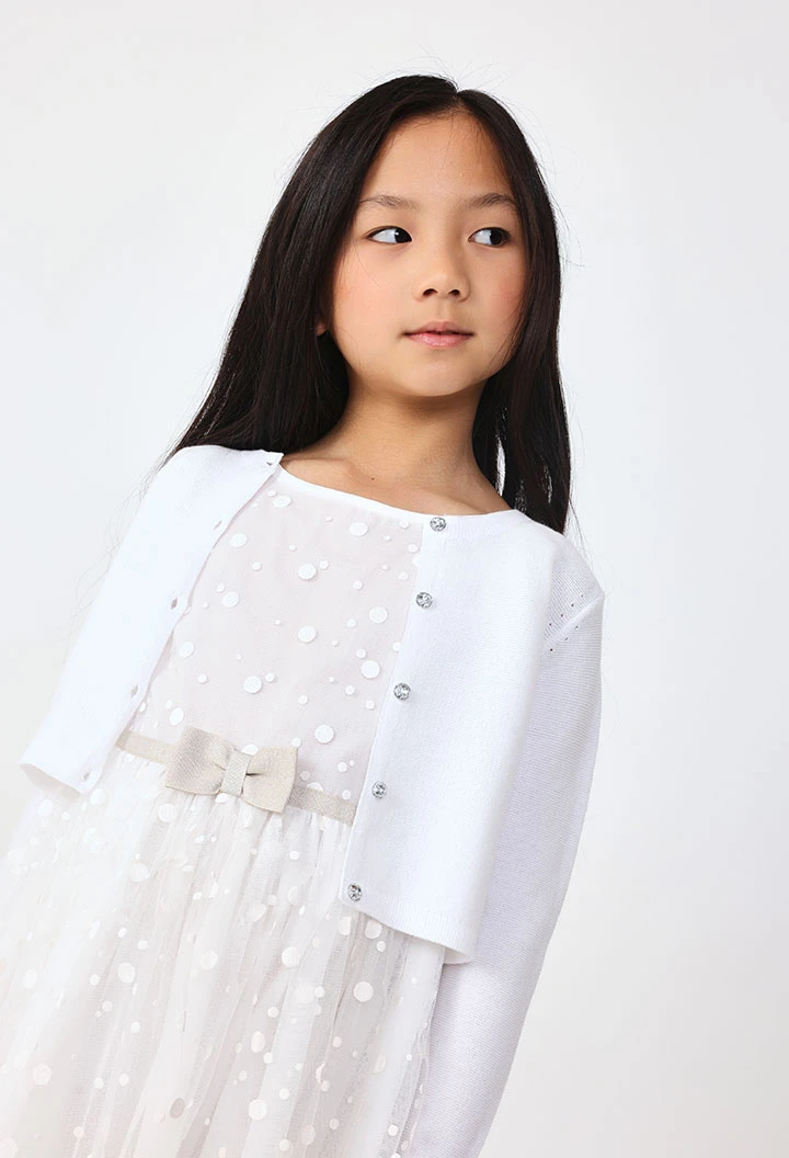 Veste en tricot pour bébé fille de couleur blanche.
