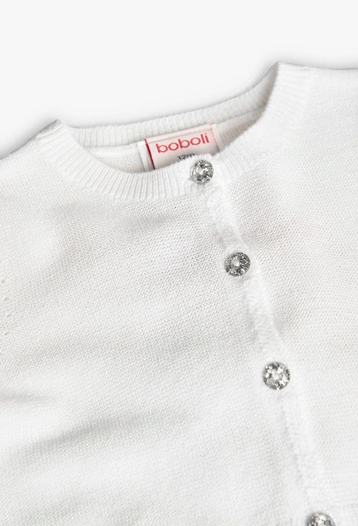 Veste en tricot pour bébé fille de couleur blanche.