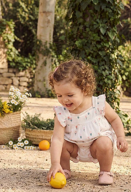 Weißes Baby-Kleid mit Blumen.