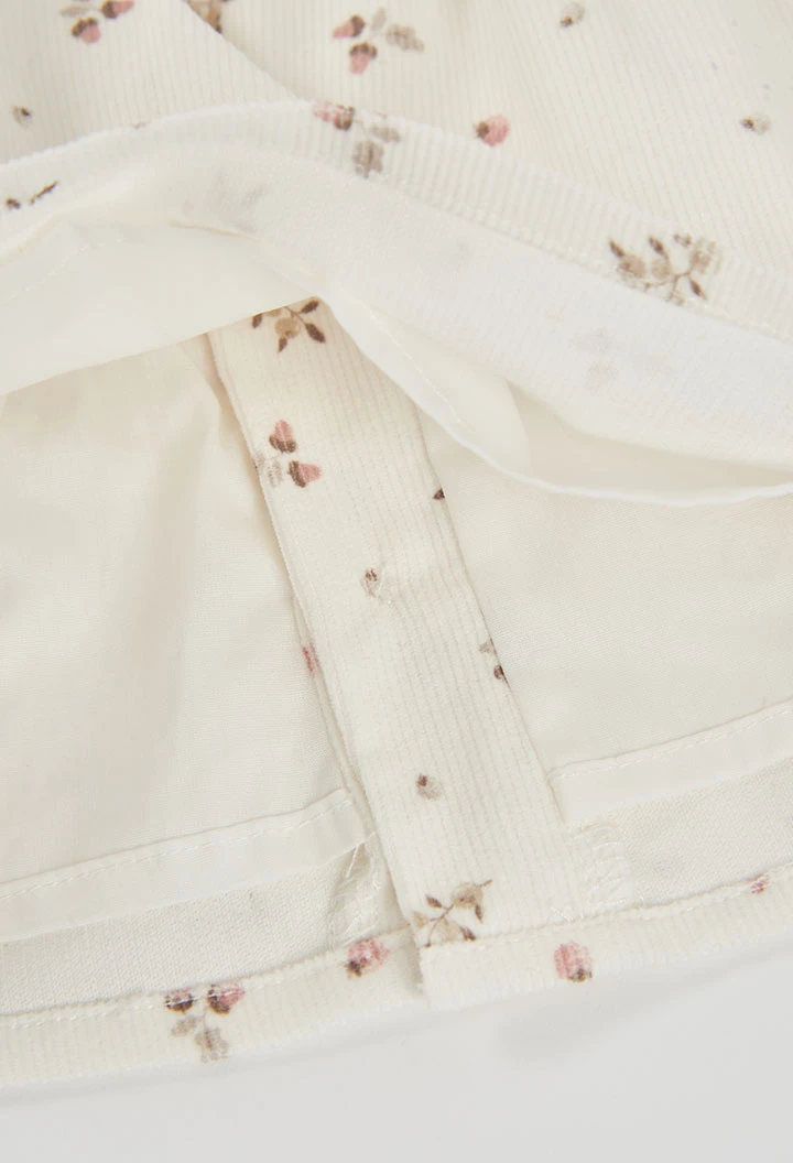 Bedrucktes Babykleid aus Mikrocord mit Blumenmuster in Naturweiß