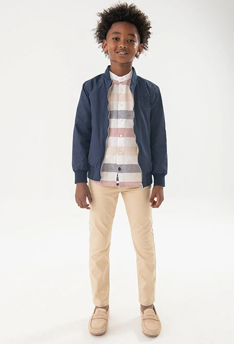 Pantaló de setí per a nen en color beige.