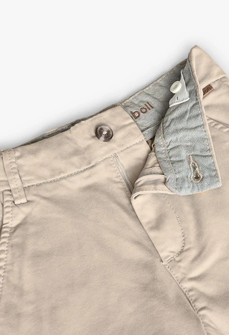 Pantaló de setí per a nen en color beige.