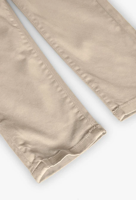 Pantaló de setí per a nen en color beige.