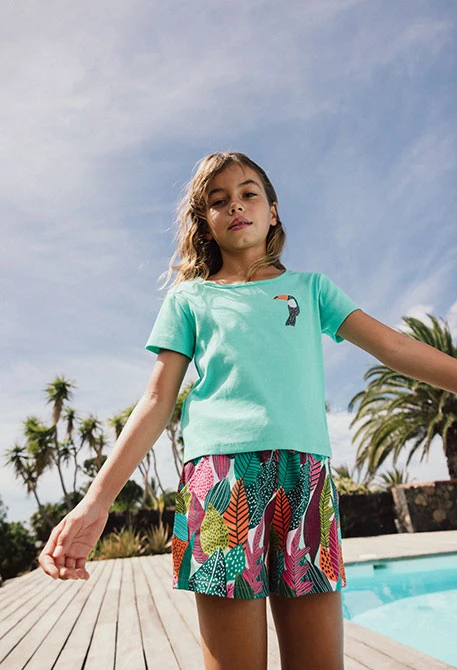 Short en maille pour fille avec imprimé de feuilles en vert et rose.