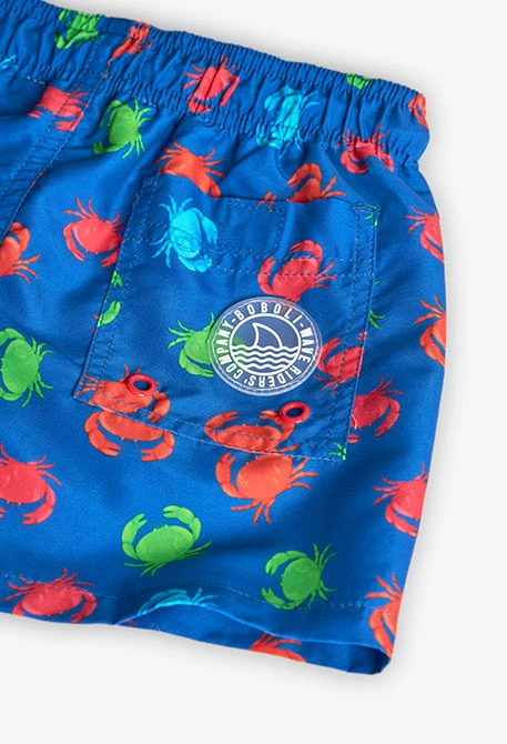 Boys\' swim trunks made from recycled fabric in blue with a crab print